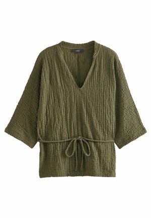 Haut en maille texturée vert olive avec larges manches trois-quarts, décolleté en V profond et ceinture à nouer ajustable à la taille.