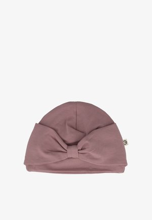 Blød, lyserød bomulds-hat med en rund top og en stor sløjfeaccent foran. Har et mærke på siden. Glat tekstur.