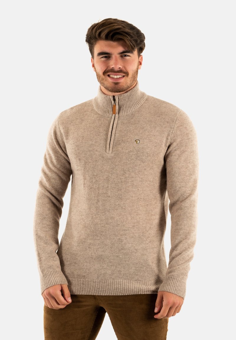 Pull en tricot beige avec un col montant, zip demi-long, poignets et ourlet côtelés. Présente un petit logo sur le côté gauche.