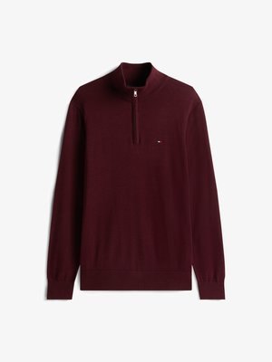 Burgundi spalvos ketvirčio užtrauktuku puloveris su aukštu apykakle, raštuotomis rankogalių ir apačios detalėmis. Ant krūtinės yra mažas logotipas, o audinys yra lygus.