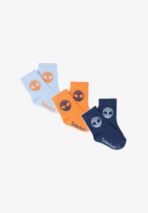 Trois paires de chaussettes pour tout-petit en bleu clair, orange et bleu marine, chacune avec un logo d'arbre et le texte « Timberland ».