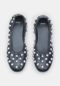 Musta nahkainen ballerina-kenkä, jossa on hopeiset niittikoristeet ja pyöreä kärki, sileällä sisävuorella ja elastisella reunalla.