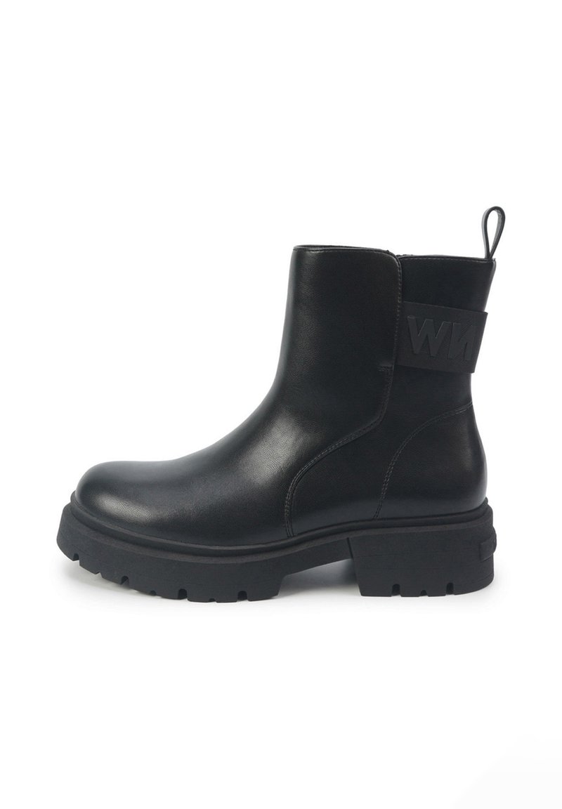 Black leather ankle boot with a chunky rubber sole, side zipper, and a textured black strap with logo detail on the back.