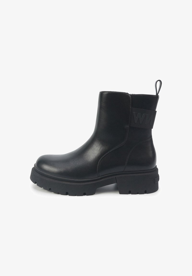 Black leather ankle boot with a chunky rubber sole, side zipper, and a textured black strap with logo detail on the back.