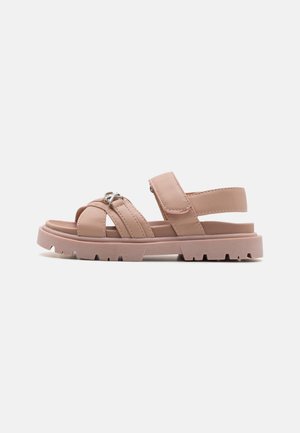 Sandali sintetici rosa con cinturini incrociati, una fascetta alla caviglia e una suola spessa e testurizzata. Chiusura regolabile con strap a strappo.