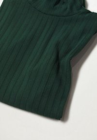 Grüner gerippter Strickstoff, der ein tailliertes Design mit vertikalen Streifen und einem hohen Kragen zeigt, flach auf einem hellen Hintergrund ausgelegt.