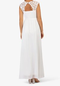 Bílé maxi šaty s našitým živůtkem, průsvitnou splývavou sukní a krajkovými krátkými rukávy, s otevřeným zadním dílem nad pasem.