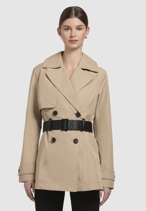 Beige topeltsadega mantlite jakk, millel on suur krae, must vöö ja nööbid. Sile kangas, pikad varrukad ja struktureeritud lõige.