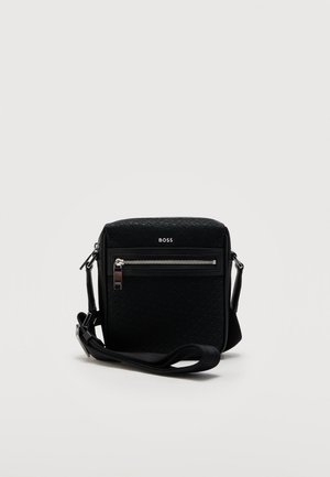 Czarna torebka na ramię z przednią kieszenią na suwak, teksturowaną powierzchnią, srebrnym suwakiem, regulowanym paskiem i logo BOSS na froncie.