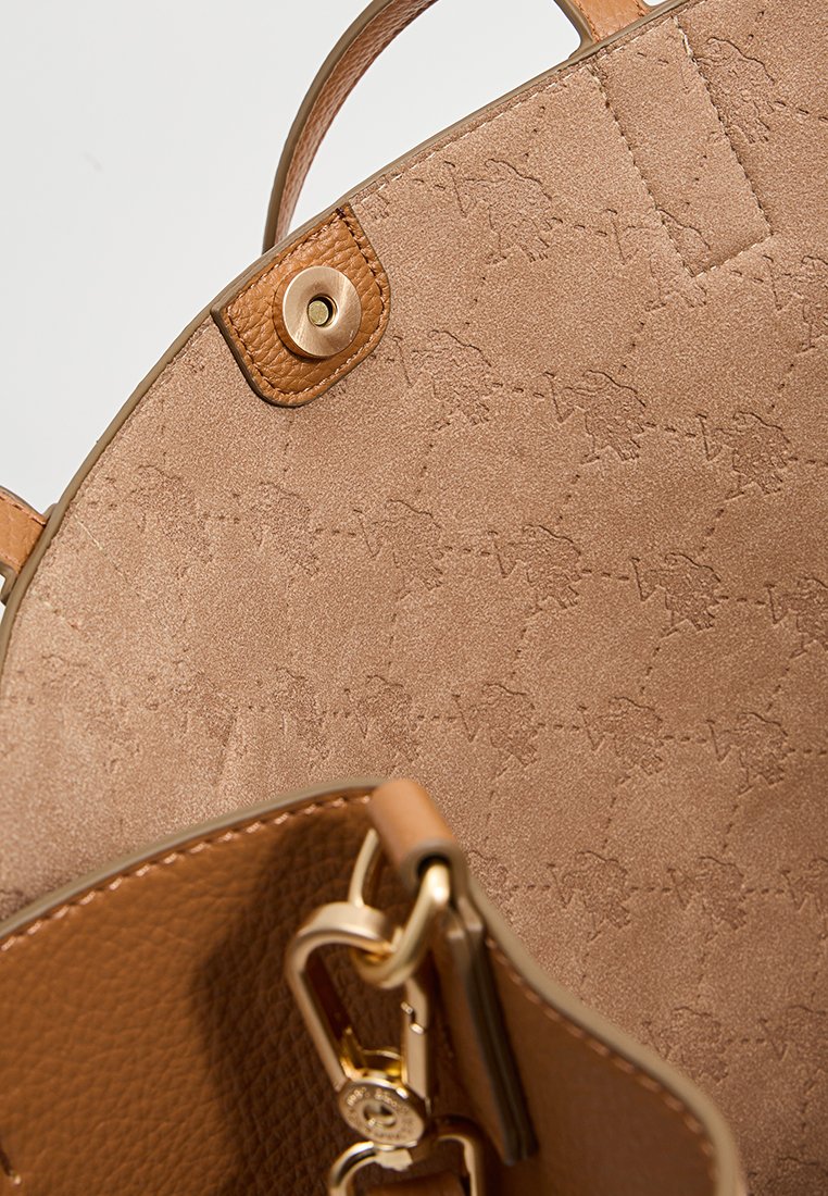 Sac à main en cuir marron avec une surface texturée, présentant un motif en relief subtil. Comprend des accessoires en or et des poignées robustes.