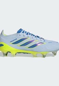 Chaussure de football Adidas Predator bleu clair avec semelle jaune néon, trois bandes iridescentes et crampons métalliques pour terrain ferme.
