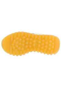 Sole of a sneaker with a textured, dotted pattern. Yellow rubber material with grooves and ridges for traction and grip.