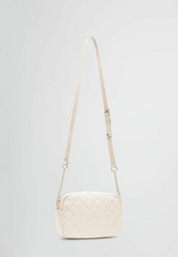 Prošívaná krémová crossbody taška s řetízkovým a látkovým uchopem. Má obdélníkový tvar, hladký povrch a prošívání ve vzoru diamantů.