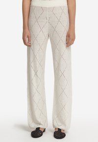 Ljust beige vida byxor med ett öppet stickat diamants mönster, som har en bekväm midja och en strukturerad tyg.
