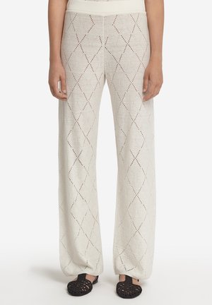 Pantalons larges beige clair avec un motif en diamant en tricot ouvert, disposant d'une ceinture confortable et d'un tissu texturé.