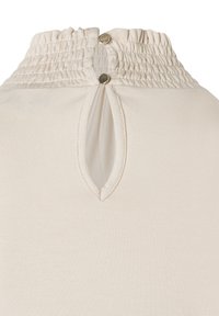 Beige Oberteil mit einem gerafften hohen Ausschnitt, einem Schlüssellochverschluss im Rücken und zwei metallischen Knöpfen zum Schließen. Weiche, glatte Stoffstruktur.