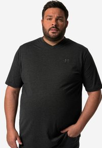 Camiseta de pico gris oscuro con mangas cortas, hecha de una tela suave. Presenta un pequeño y sutil logo en el pecho. Corte y diseño clásico.