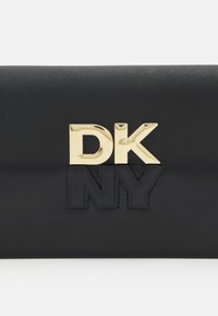 Schwarze Leder-Clutch mit goldfarbenem DKNY-Logo. Hat eine glatte Textur und eine rechteckige Form. Minimalistisches Design mit geprägten Akzenten.