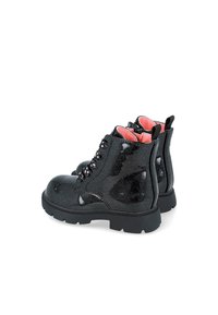 Botines negros con purpurina y acabado brillante, punta redondeada, seis ojales para cordones negros y forro interior de color rosa brillante, con suelas negras resistentes.