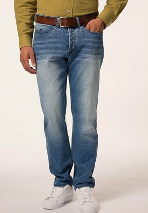 Jeans in denim azzurro chiaro con una finitura sbiadita, slim fit, cinque tasche e cintura in pelle marrone, abbinati a sneakers bianche.