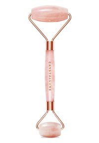 Różowy kwarcowy wałek do twarzy z podwójnymi końcami; posiada gładki, owalny kamień oraz okrągły kamień. Metaliczne akcenty w kolorze różowego złota na teksturowanym uchwycie.