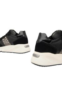 Sneaker nera caratterizzata da un mix di materiali lisci e scamosciati, con dettagli argentati e una suola bianca spessa. Forma arrotondata e design moderno.