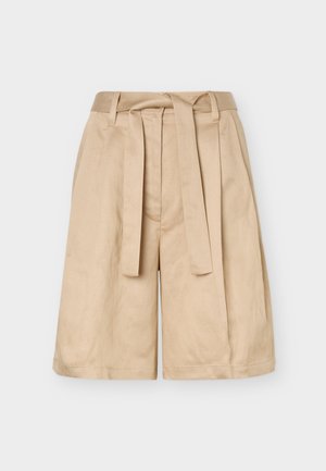 Short beige taille haute avec passants pour ceinture, ceinture en tissu à nouer et jambes larges, présenté sur un fond uni.
