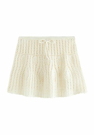 Witte gehaakte rok met een trekkoord in de taille en een uitlopende silhouet.