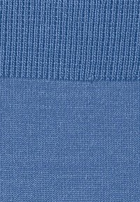 Nahaufnahme eines weichen, strukturierten Stoffes in Hellblau, der gerippte und glatt gestrickte Muster aufweist, ohne sichtbare Logos oder Designs.