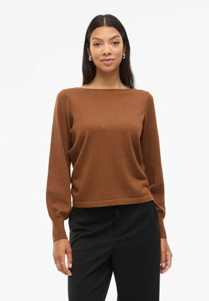 Pull marron à manches longues avec un col carré et des poignets côtelés, associé à un pantalon noir. Texture douce avec une coupe décontractée.
