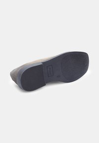 Shoe sole with a gray suede upper and black rubber outsole. Features a textured grip and slight heel, with a logo embossed on the side.