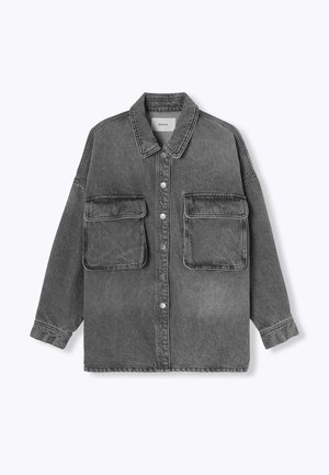 Veste en denim noir surdimensionnée décolorée avec fermeture à boutons, deux grandes poches à rabat sur la poitrine et un col classique.