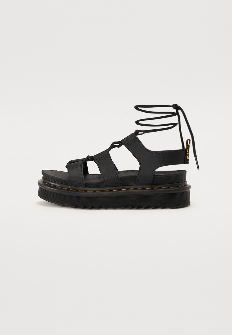 Black platform sandals with multiple straps, lace-up design, textured rubber sole, and contrasting stitching along the edge.
