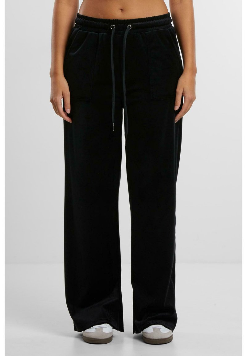 Pantalons larges noirs en tissu doux, dotés d'une taille ajustable avec cordons de serrage et de deux poches avant.