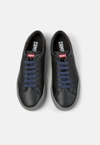 Black leather shoes with navy laces, gray soles, and visible stitching. The inner lining features the Camper logo in white.