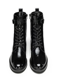 Botas de tobillo de charol negro con parte superior con cordones, cremallera lateral y suela de goma gruesa. Textura suave y acabado pulido.