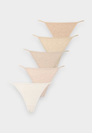Cinq paires de strings sans coutures pour femmes dans différentes nuances de nude et beige, empilées en diagonale sur un fond neutre.