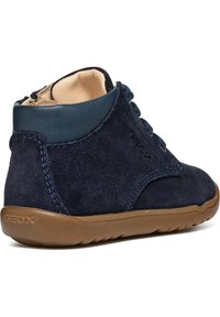 Stivale alla caviglia in suede blu navy con suola in gomma, stringato davanti e colletto in pelle a contrasto. Presenta il marchio Geox sul lato.