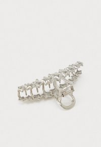 Hõbedane metallist juukseaksessuaar, millel on tähte kujutavad aksessuaarid, sile pind ja klamber turvaliseks kinnitamiseks.