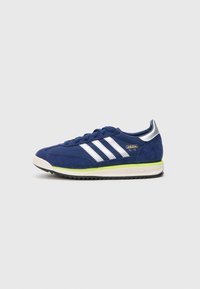 Námornícky modré tenisky Adidas SL 72 s bielymi pruhmi, s limetkovou zelenou akcentovanou strednou podrážkou a reflexnou striebornou pätnou nášivkou, orientované doľava na bielom pozadí.