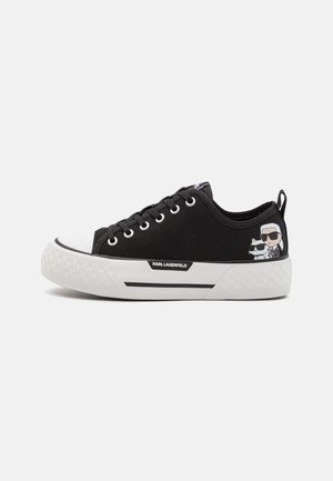 Zwarte lage sneaker met witte zool, Karl Lagerfeld-logo en een cartoonafbeelding van een man met zonnebril en een kat aan de zijkant.