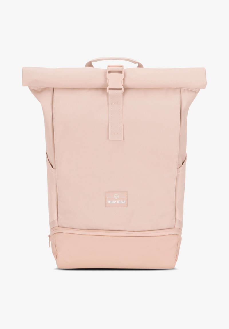 Rulltopp ryggsäck i mjuk rosa tyg. Utrustad med justerbara axelremmar, sidofickor och en framsida med etikett. Slät textur, minimalistisk design.