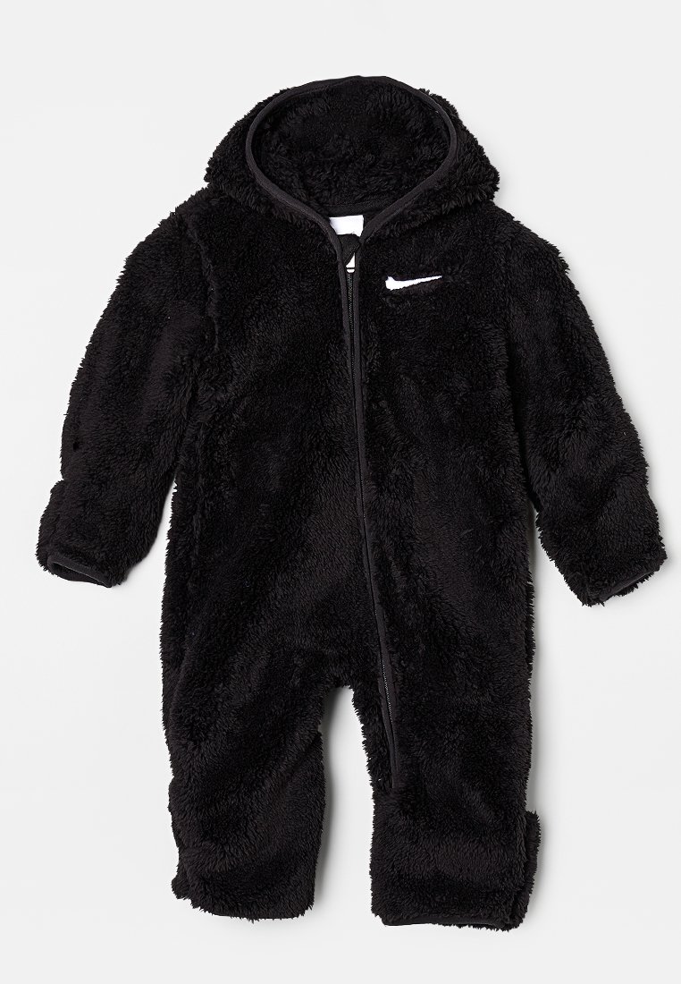 Mono de felpa negra con capucha, cierre de cremallera y logo de Nike en el pecho. Presenta mangas largas y piernas holgadas. Textura suave.