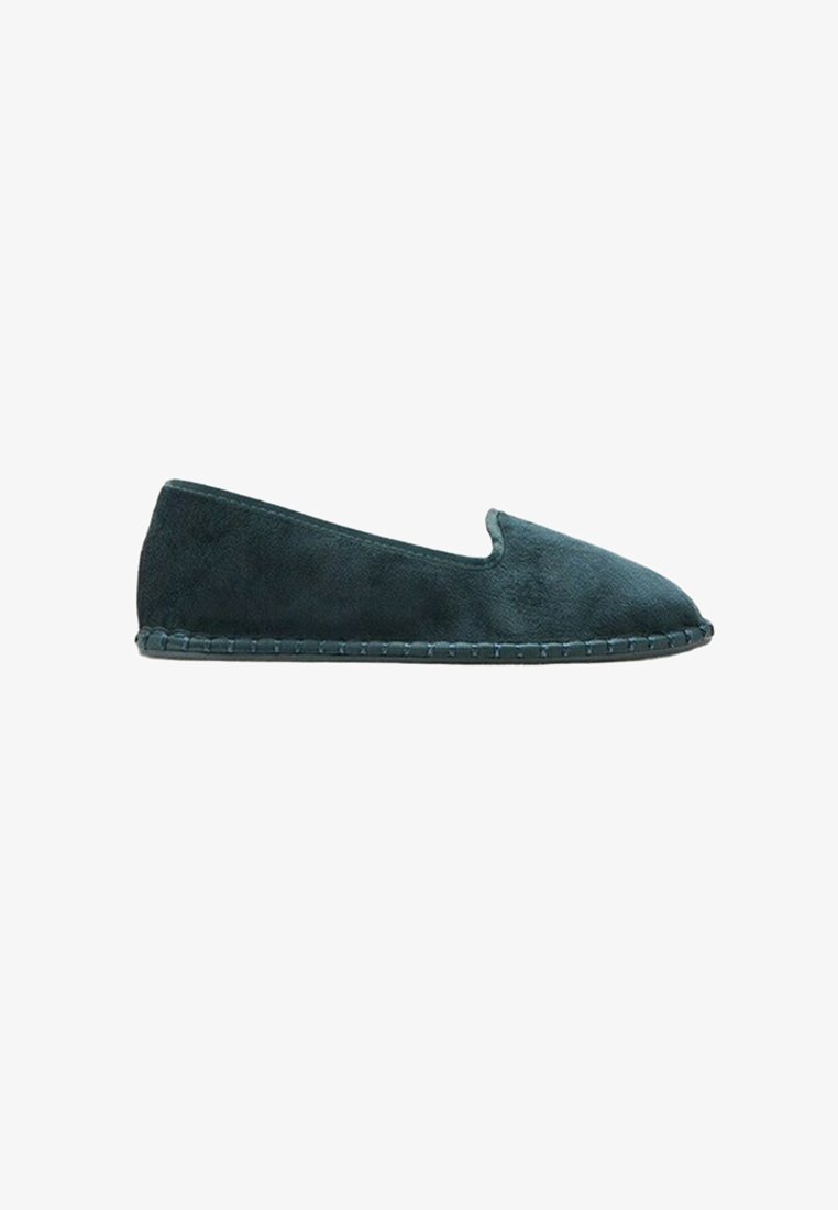 Dark green suede slip-on flat shoe with a rounded toe and visible stitching along the sole.