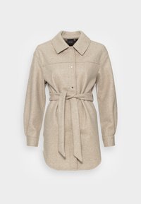 Giacca di lana beige a maniche lunghe con colletto, bottoni a pressione e cintura legata in vita, presentata su uno sfondo chiaro e semplice.