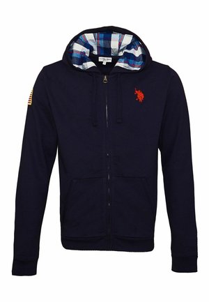 Sweat à capuche zippé bleu marine avec capuche doublée en tissu à carreaux, poches avant, logo de cheval rouge sur la poitrine et patch drapeau américain sur la manche gauche.