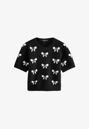 Schwarzer, flauschiger Pullover mit kurzen Ärmeln, der ein sich wiederholendes Muster von weißen Schmetterlingssilhouetten auf dem Stoff zeigt.