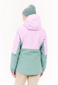 Giacca colorata con una parte superiore lilla e una parte inferiore turchese. Realizzata in un materiale morbido, con cappuccio e polsini elasticizzati.