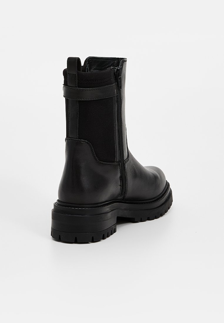 Schwarze Leder-Stiefeletten mit seitlichem Reißverschluss, elastischen Einsätzen, dicker Gummisohle und glatter Textur. Mit Zuglasche für ein einfaches Anziehen.
