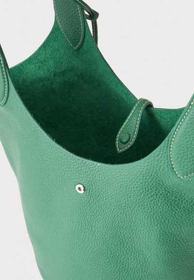 Sac cabas en cuir vert texturé avec deux poignées et une fermeture pression, dévoilant un intérieur doux en daim.